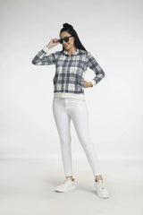 Woman wearing a plaid shirt, white pants, and sneakers on a white background