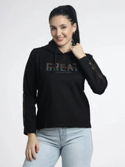 Woman wearing a black hoodie with 'GREAT' text on a white background