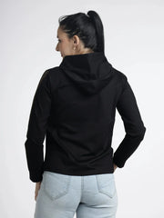 Person wearing a black hoodie and light blue jeans on a white background