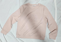 Pink sweatshirt with floral embroidery on a light gray background