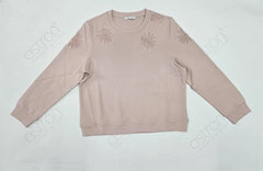 Beige sweatshirt with floral embellishments on a light gray background