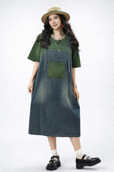 Woman wearing a green shirt, denim dress, and black shoes on a white background