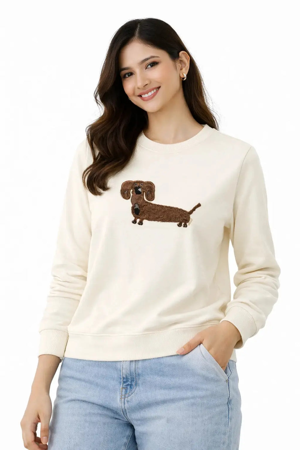 Woman wearing a cream sweater with a dachshund design on a white background