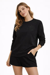 Woman wearing a black sweatshirt and shorts on a white background