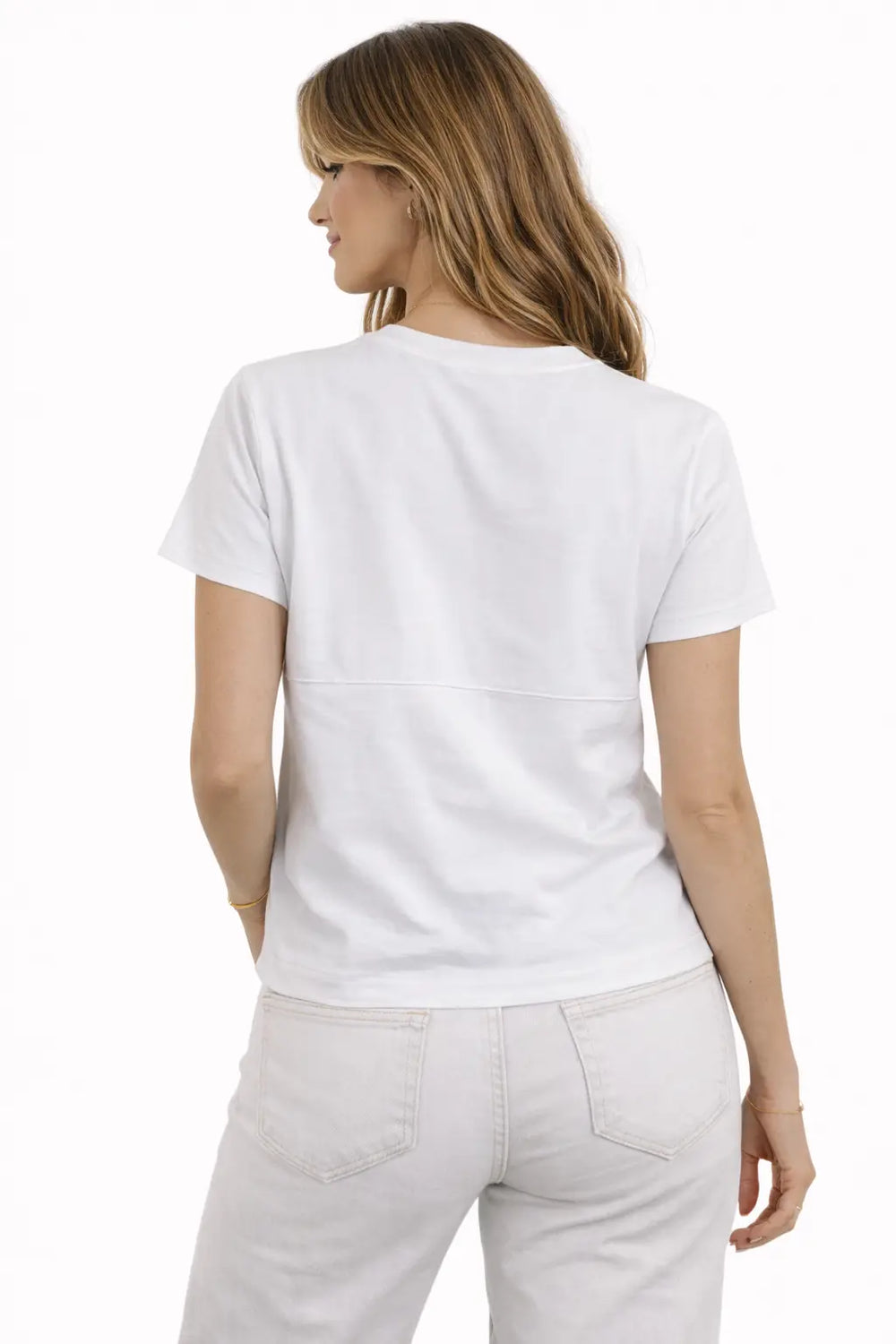 Woman wearing a plain white t-shirt and light-colored pants on a white background
