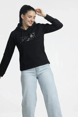 Woman wearing a black hoodie with text and light blue jeans on a white background