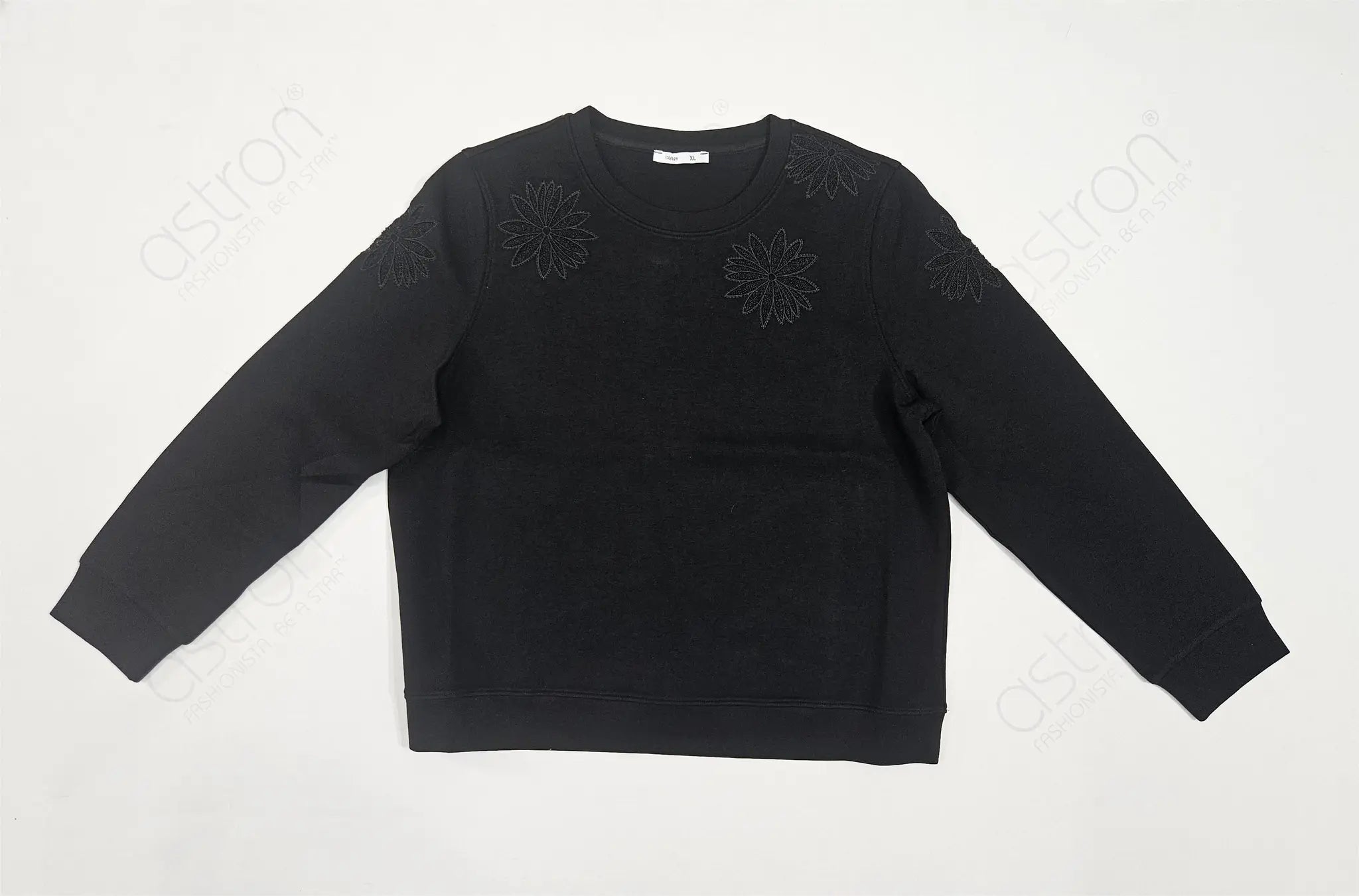 Black sweater with floral patterns on a white background