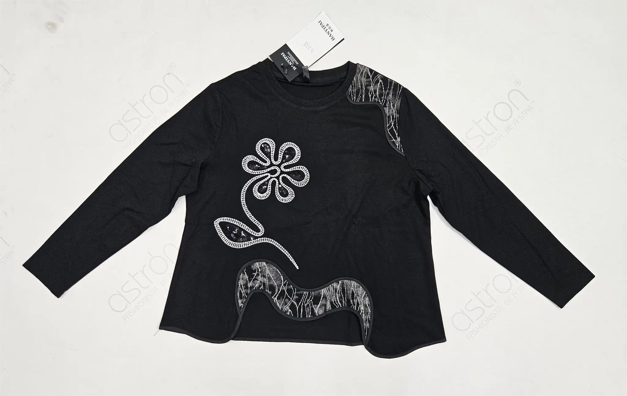 Black long-sleeve shirt with white floral design on a light gray background