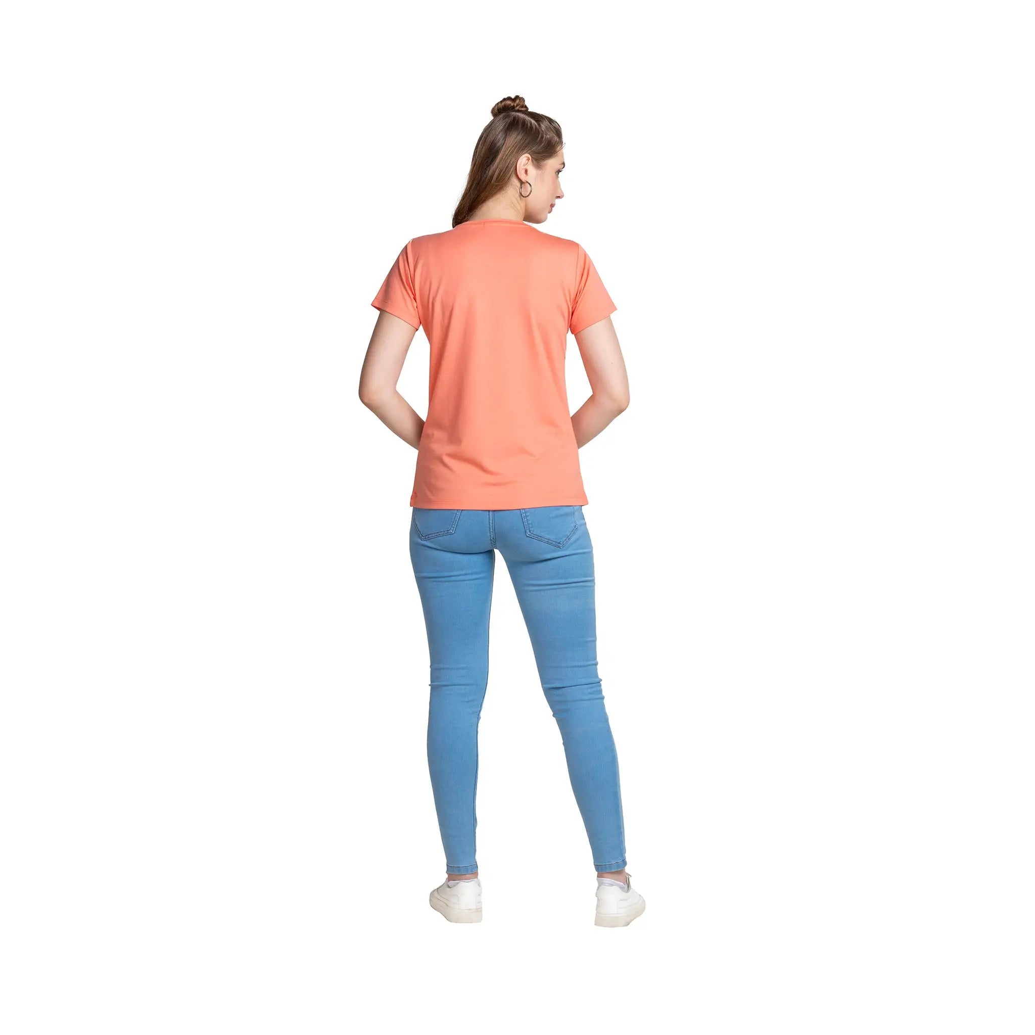 Person wearing a coral t-shirt and blue jeans on a white background