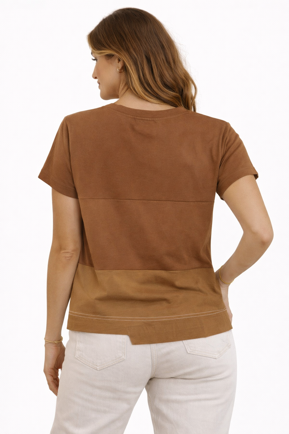 Woman wearing a brown top and white pants on a white background