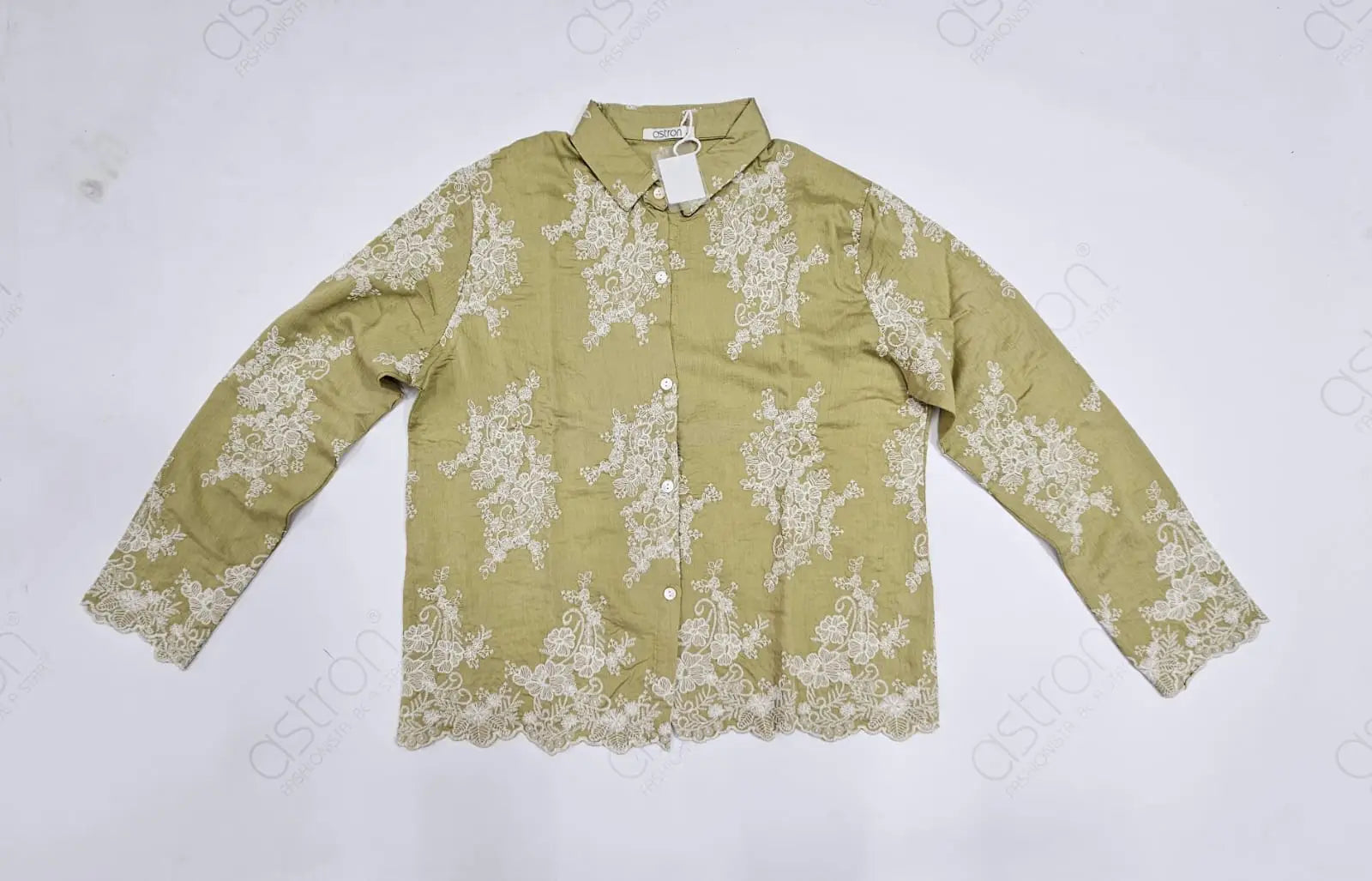 Green shirt with white floral embroider details on a light gray background